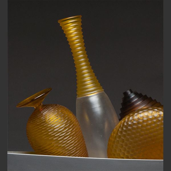 artwork of miniature amber glass vases in long silver tray