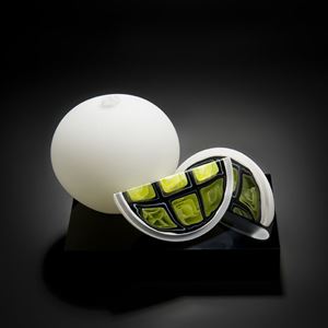 sculpted glass artwork of two fruit in white with one cut to show lime coloured interior