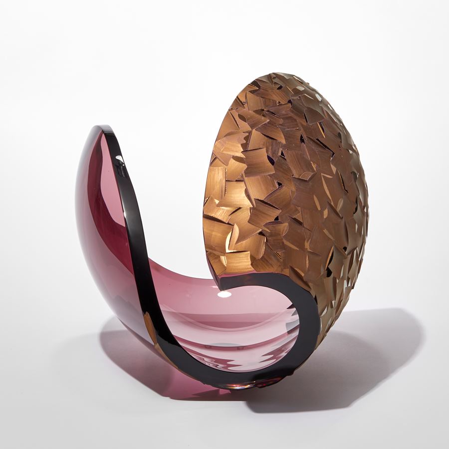 transparent aubergine ovoid with sweeping cut away section leaving a dramatic curved edge with one side covered in a deep incised cut organic pattern finished in gold hand made from glass