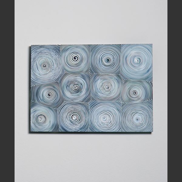 triptych of modern glass wall art with circular patterns in shades of blue and grey