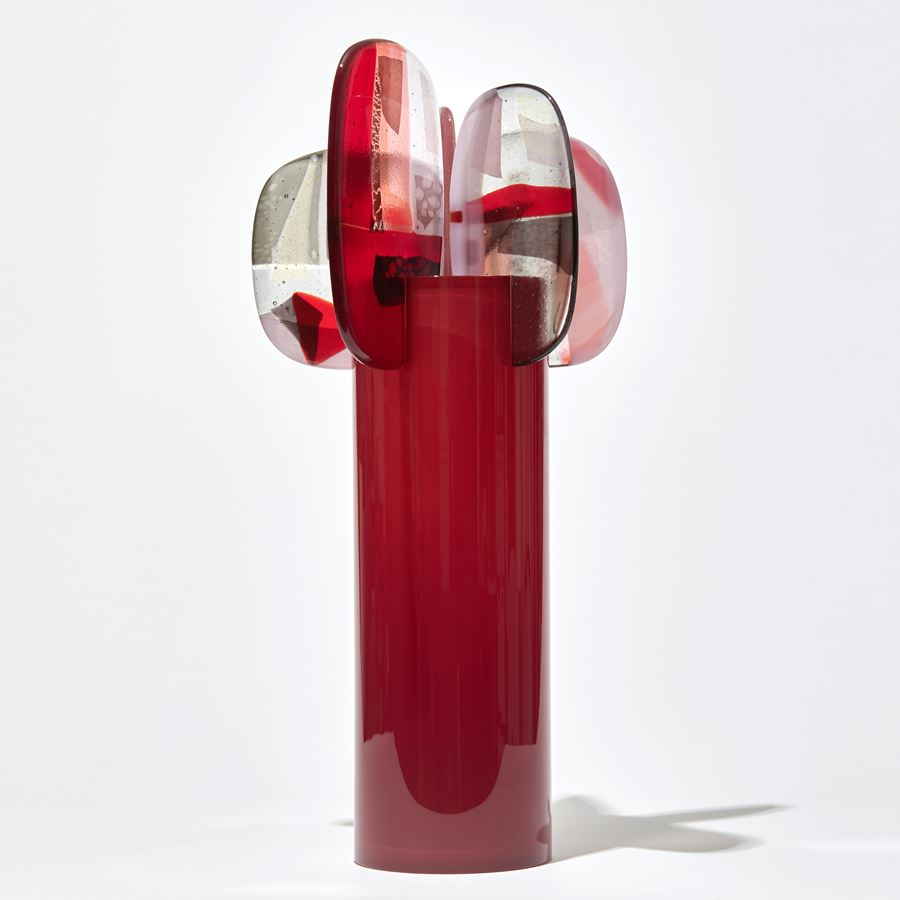rich oxblood red cylinder with five finials perched on the rim with abstract patterns in aubergine red and pink hand made from blown and fused glass by amy cushing