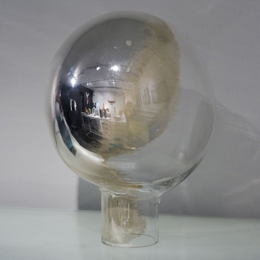 globe shaped minimalist glass sculpture resembling a mirror in white and pearl