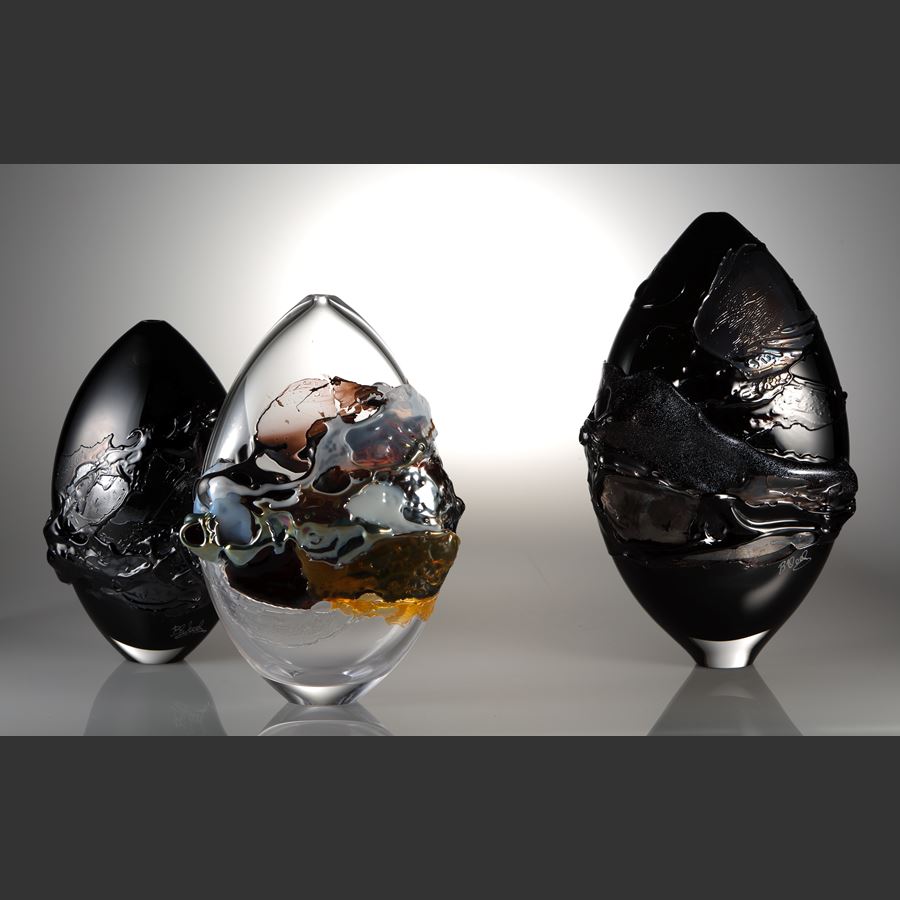 oval shaped black coloured art-glass vessel with external abstract pattern