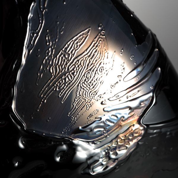 black oval shaped art glass sculptural vessel with gold splashes