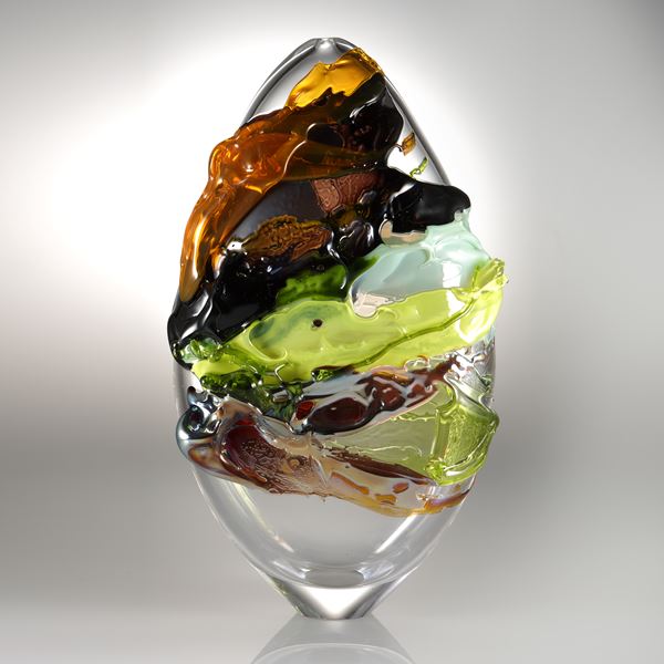 decorative oval shaped glass art sculpture with graffiti coloured exterior 