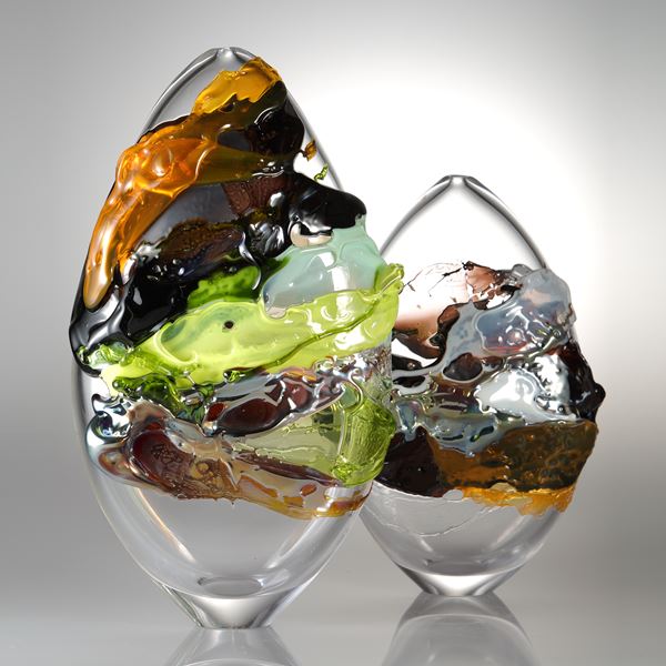 decorative oval shaped glass art sculpture with graffiti coloured exterior 