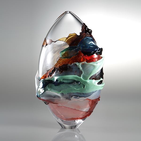 oval shaped blown clear glass vessel with splashes of dark orange light green and pink colour