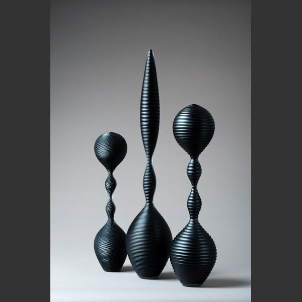 a trio of abstract black sculpted glass ornaments in different sizes