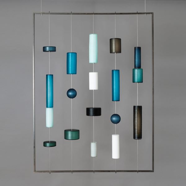 modern glass wall art with pieces held by wire on hollow steel frame