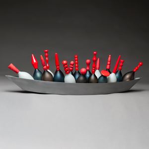 artwork of red topped glass skittles in long steel tray