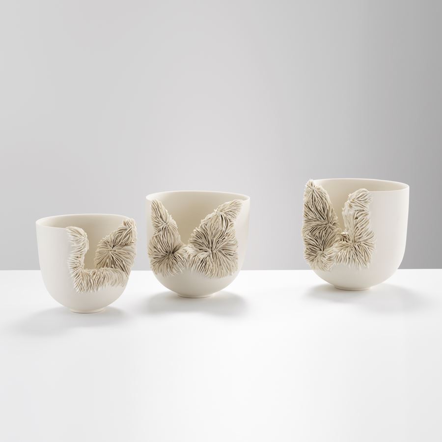 white ceramic sculpture of a tall bowl with collapsed side revealing layered pattern
