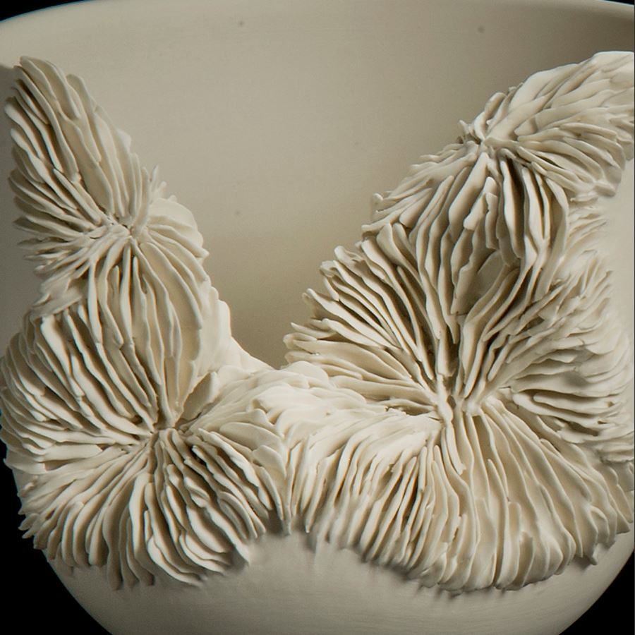 white porcelain sculpted tall bowl with collapsed side recealing complex layered pattern