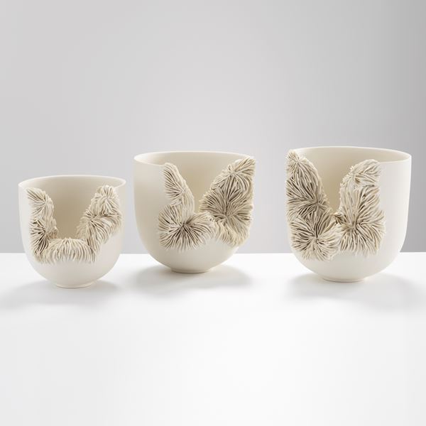 white porcelain sculpted tall bowl with collapsed side recealing complex layered pattern
