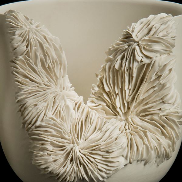 white ceramic sculpture of a tall bowl with collapsed side revealing layered pattern