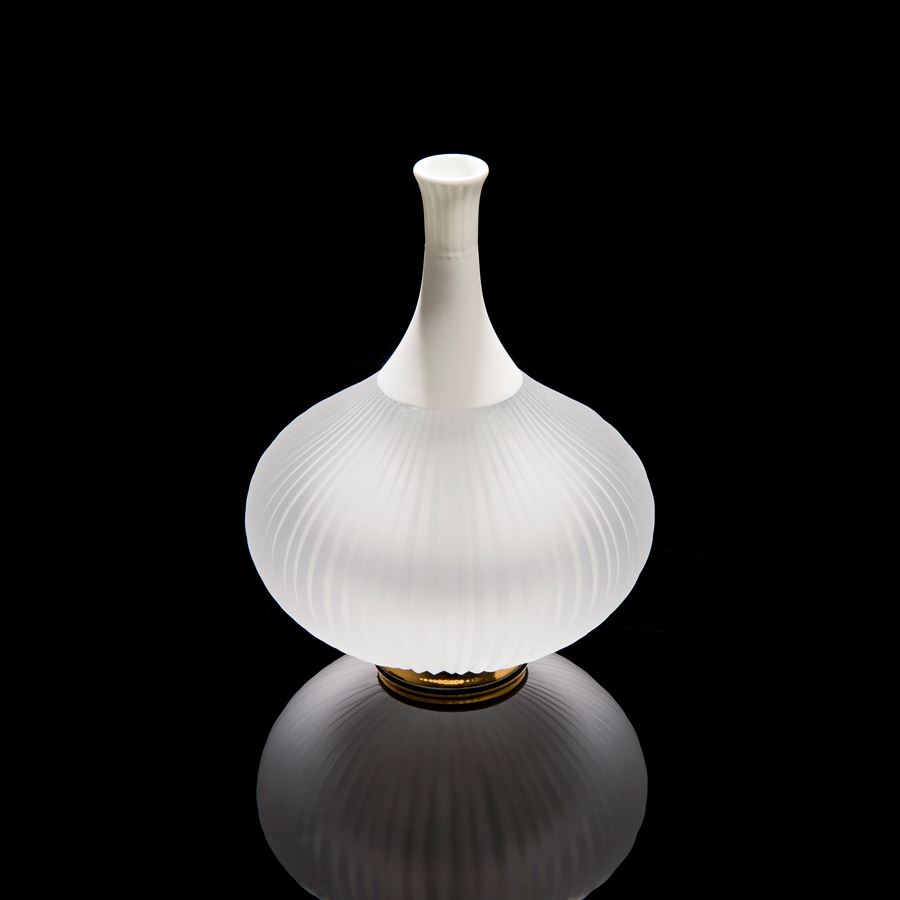 sculpted white vessel with wide glass base and long porcelain neck on gold base
