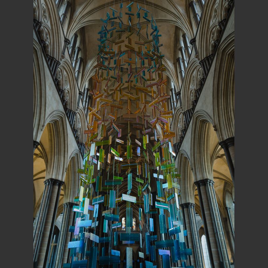 hanging glass installation from handmade fused glass components complementing church stained glass window colours