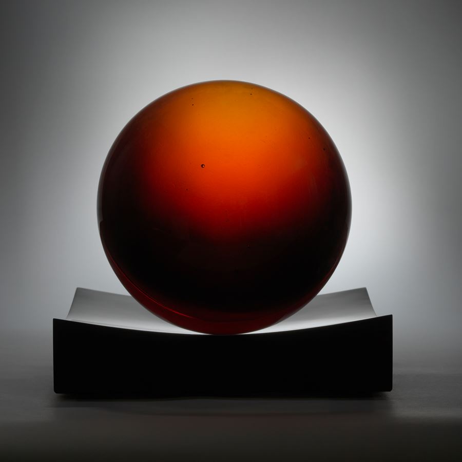 red minimalist art glass spherical sculpture with central line motif