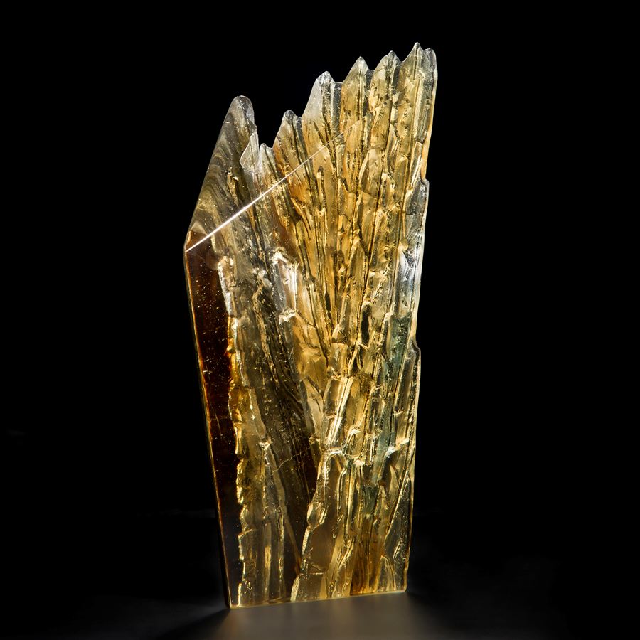 cast glass sculpture of rugged cliff edge in clear and dark colours