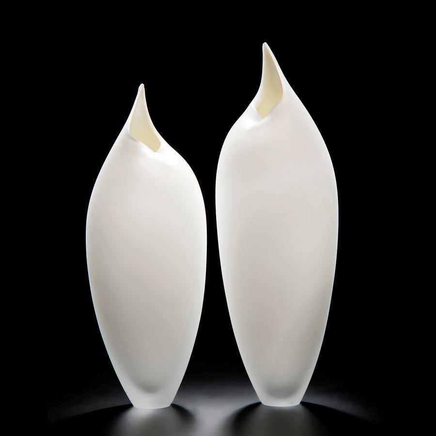 two minimalist art-glass sculptures in white shaped like birds