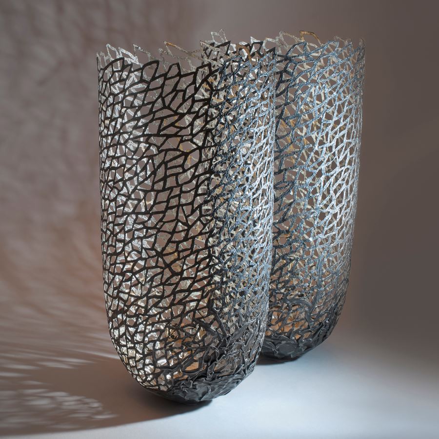 two modern art sculpted vessels made from steel and gold 