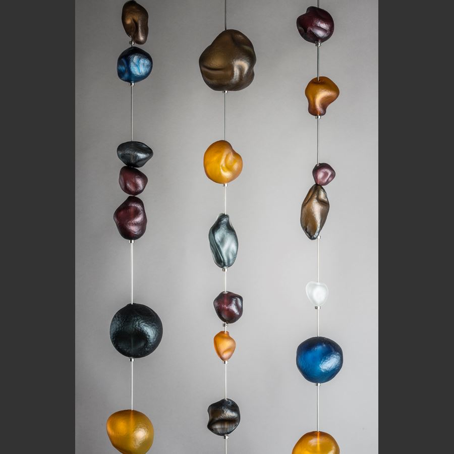 hanging art glass sculpture of brightly coloured pebble shaped glass pieces in rectangular frame