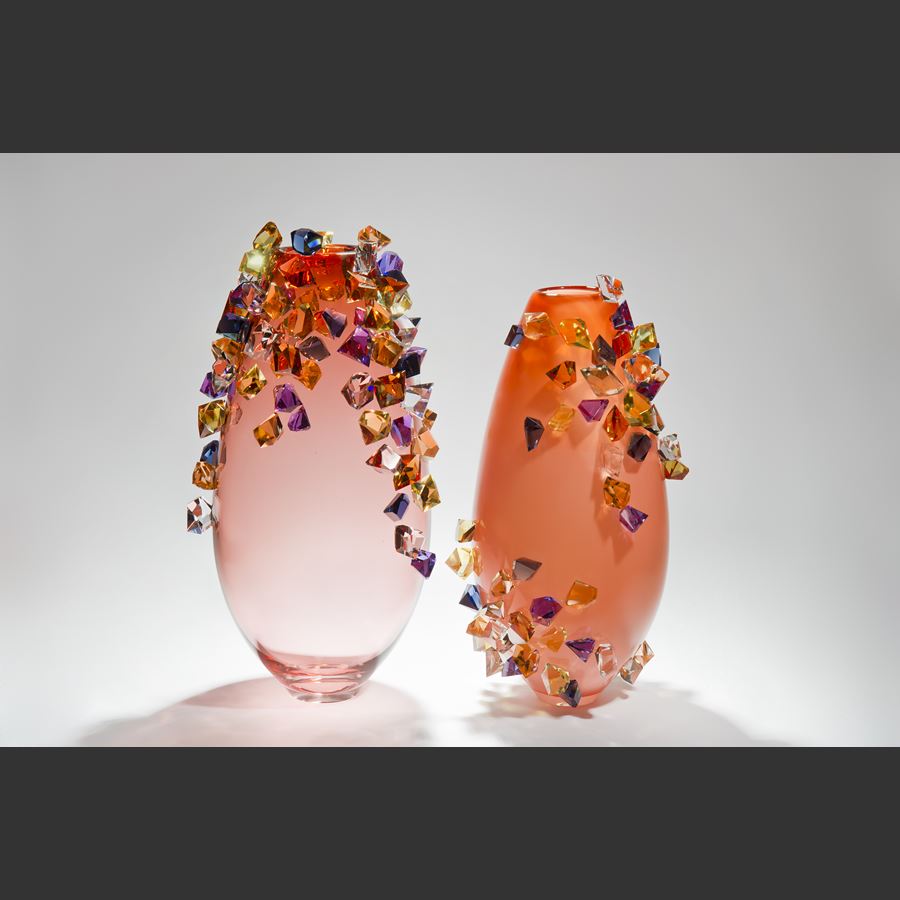 tall handblown glass-art case in peach with colored crystals adorning the outer edges