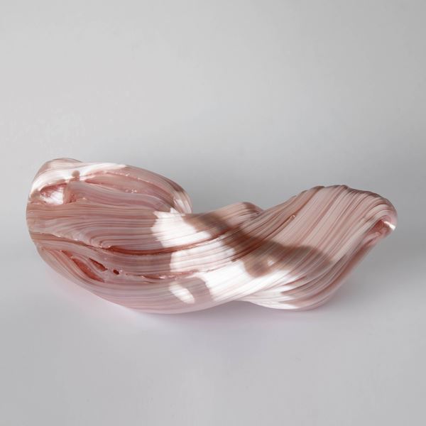 stretched and bent glass formation of abstract sculpture in pink and coral