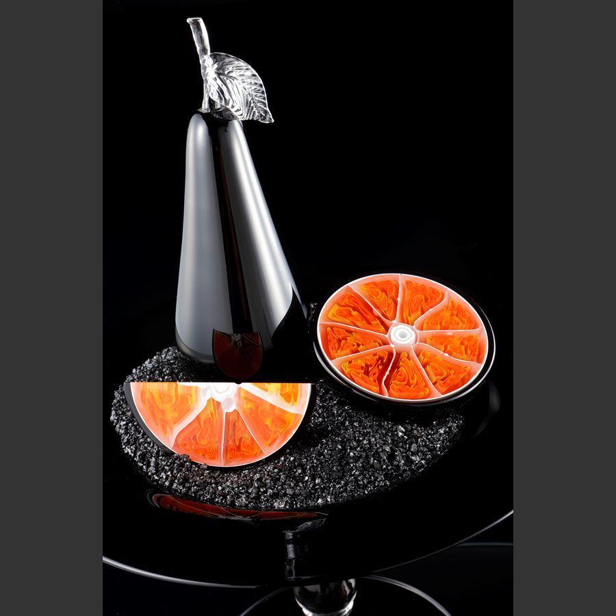 still life artwork in black carbon and orange made from handblown and sculpted glass