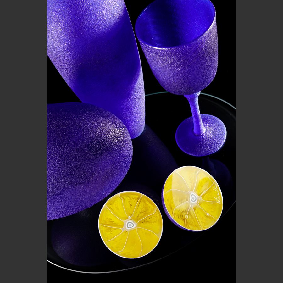 handblown and sculpted glass art still life in blue and yellow of lemons and ornaments