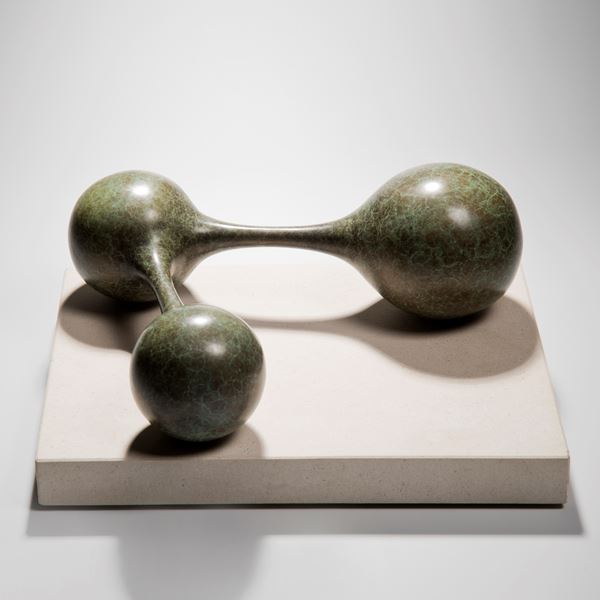 bronze minimalist sculpture of connected spheres on limestone base