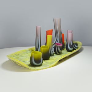 art glass sculpture with flat green base and sprouting shapes in various colours