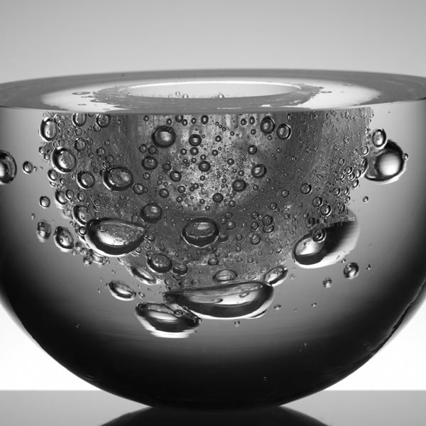 rounded dark glass sculpture with cut top revealing inner details