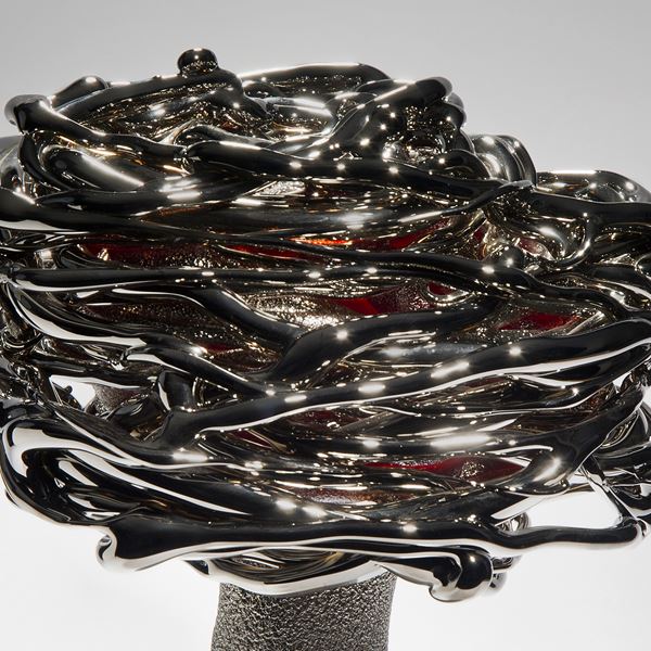 black red and platinum art-glass sculpture from blown glass of flower in wind