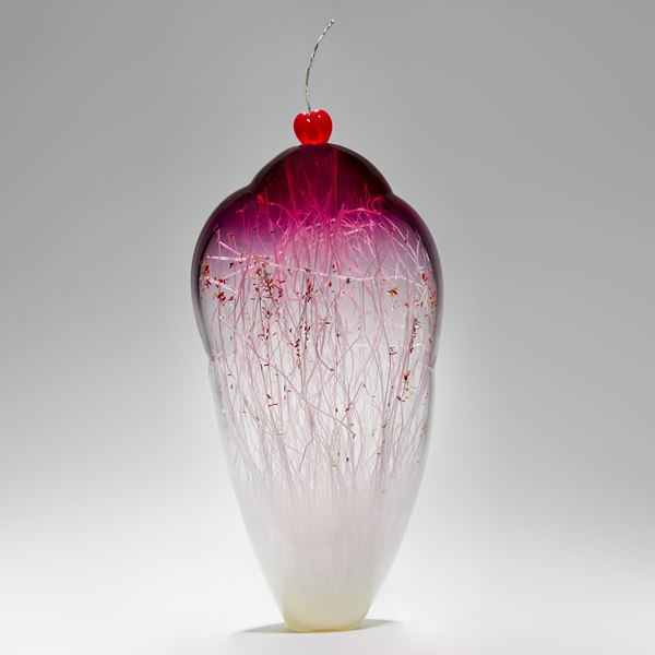 tall and thin decorative glass ornament in white and pink with natural looking internal structure and cherry on top