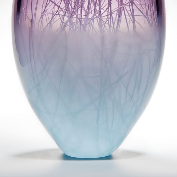 oblong shaped glass sculpture in pale turquoise and indigo with internal wire structure resembling tree branches
