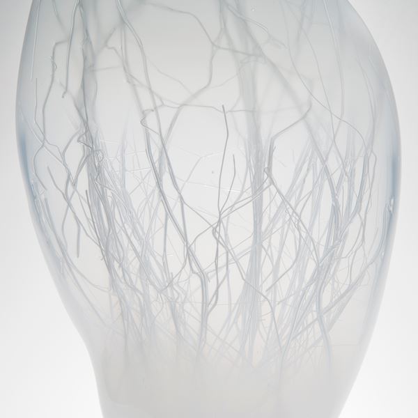 grey floating orb shaped art glass sculpture with internal tree branch structure