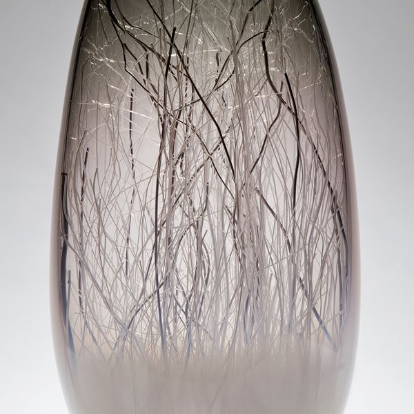 sculpted glass vessel in grey with wire interior resembling winter forest