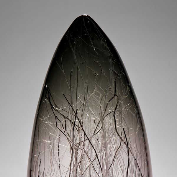 sculpted glass vessel in grey with wire interior resembling winter forest