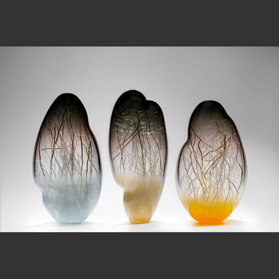 sculpted glass vessel in grey and yellow with internal wire structure