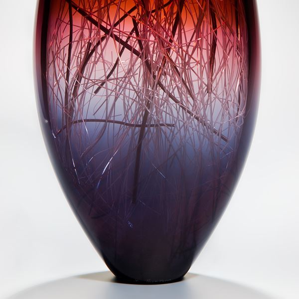 tall sculpted glass vase in deep violet red and black with internal wire structure