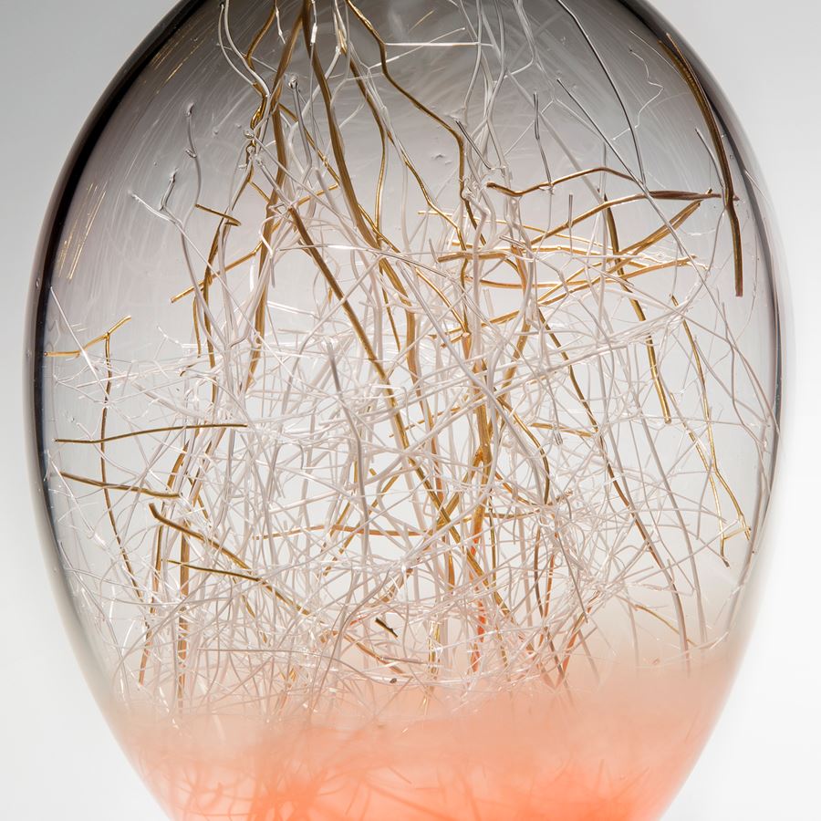 hand blown glass orb withgold wire internal structure and salmon coloured base