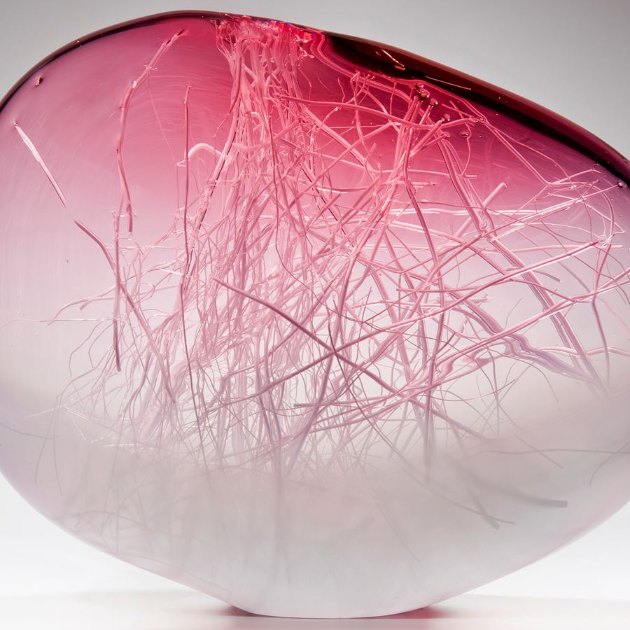orb shaped art glass sculpture in pink and white with internal wire structure