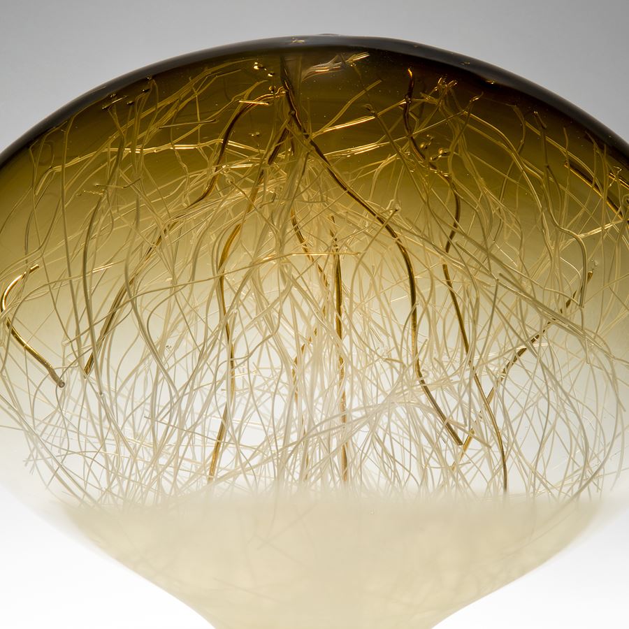 orb-shaped green and beige coloured glass sculpture with delicate nature-inspired internal structure 