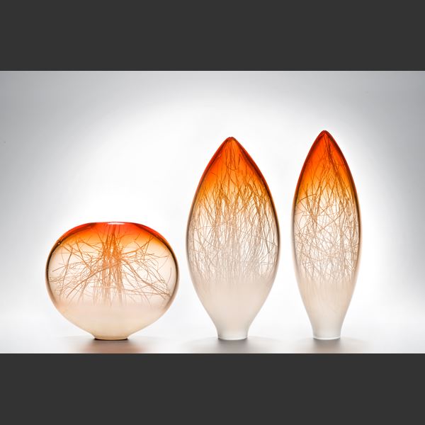orange coloured apple shaped glass ornament with internal structure resembling tree branches