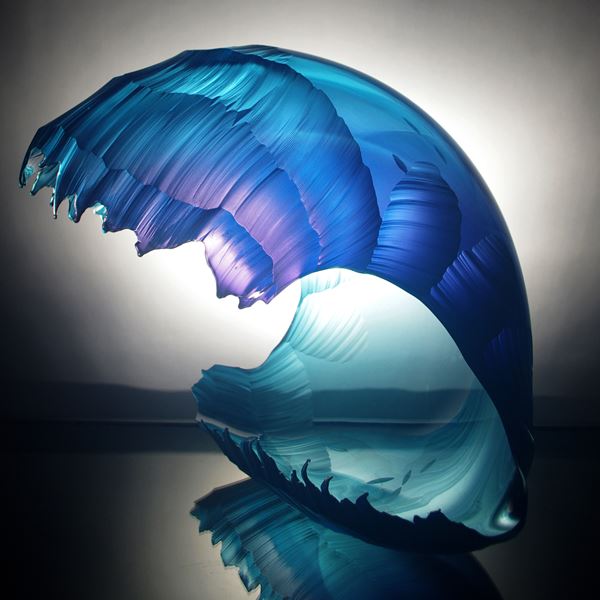sculpted glass artwork in the shape of a wave with different shades of blue