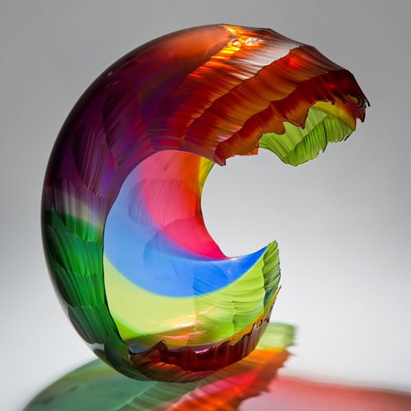 bright multicoloured art glass sculpture in the shape of a wave