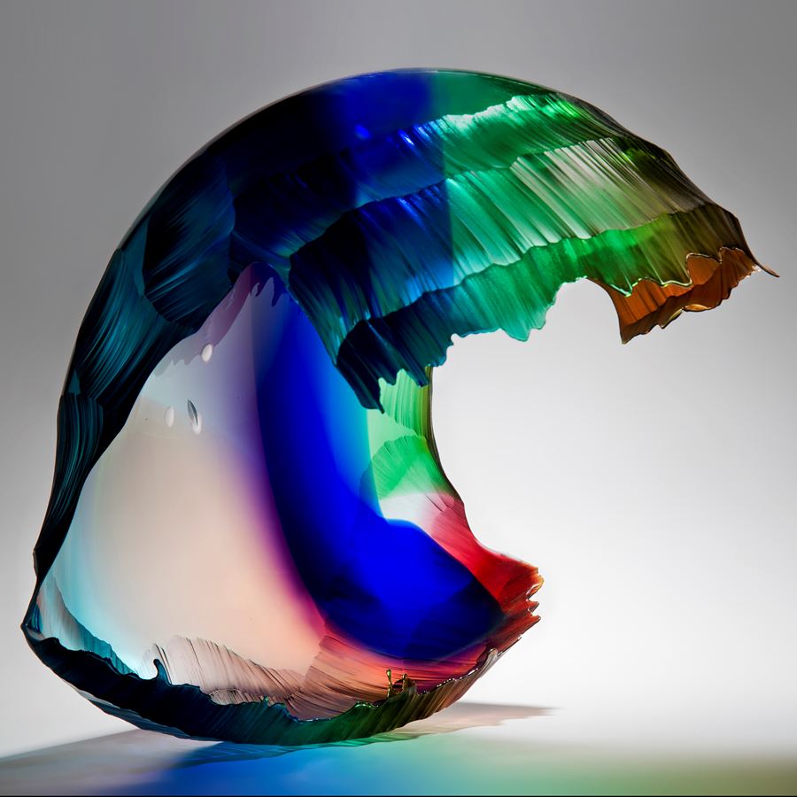 art glass sculpture of wave in bright green blue and red colours