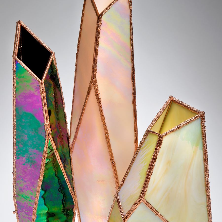 three crystal shaped glass art vases in oil coloured glass and copper frame