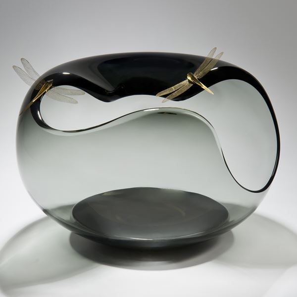 abstract clear and grey glass art bowl shape with wide open edges adorned by gold plated dragonflies