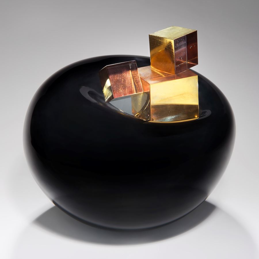 black modern rounded art glass sculpture with gold glass cubes in centre